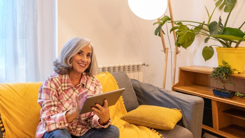 gray haired mature woman, smart home home control on tablet - use smart home app