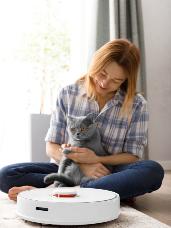 Robot vacuum cleaner, girl and cat in living room interior, smart home concept.