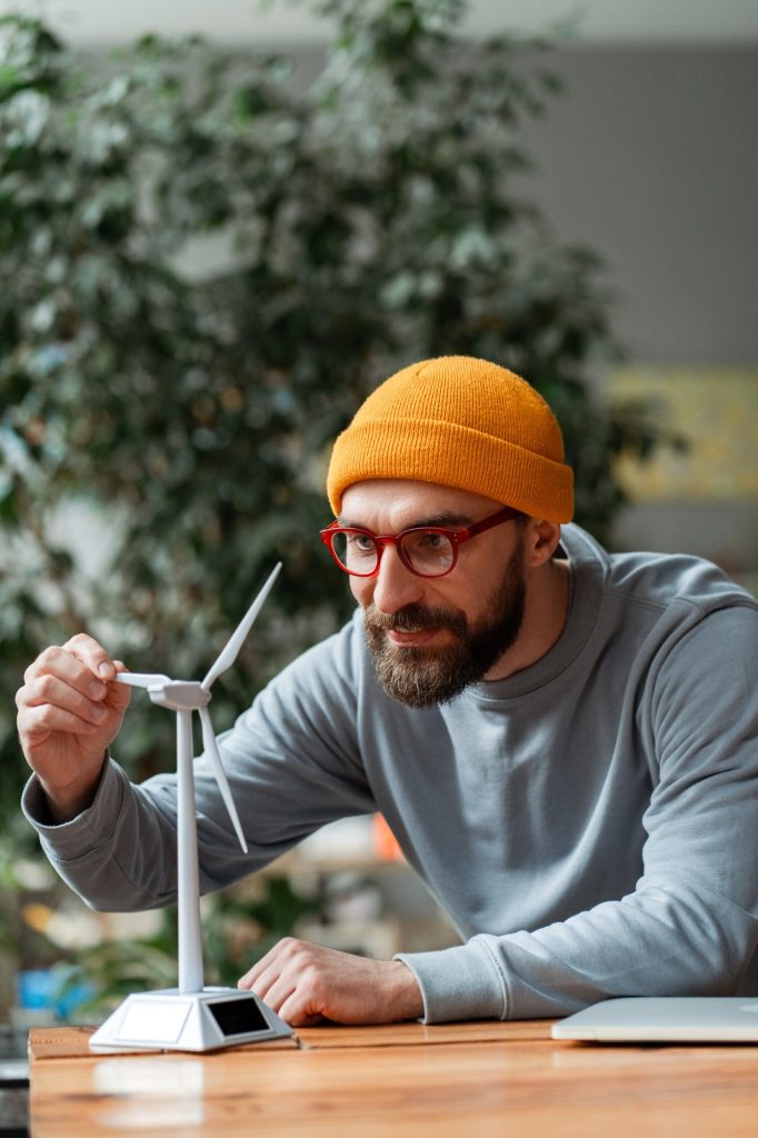 Engineer examining small wind turbine model for renewable energy project