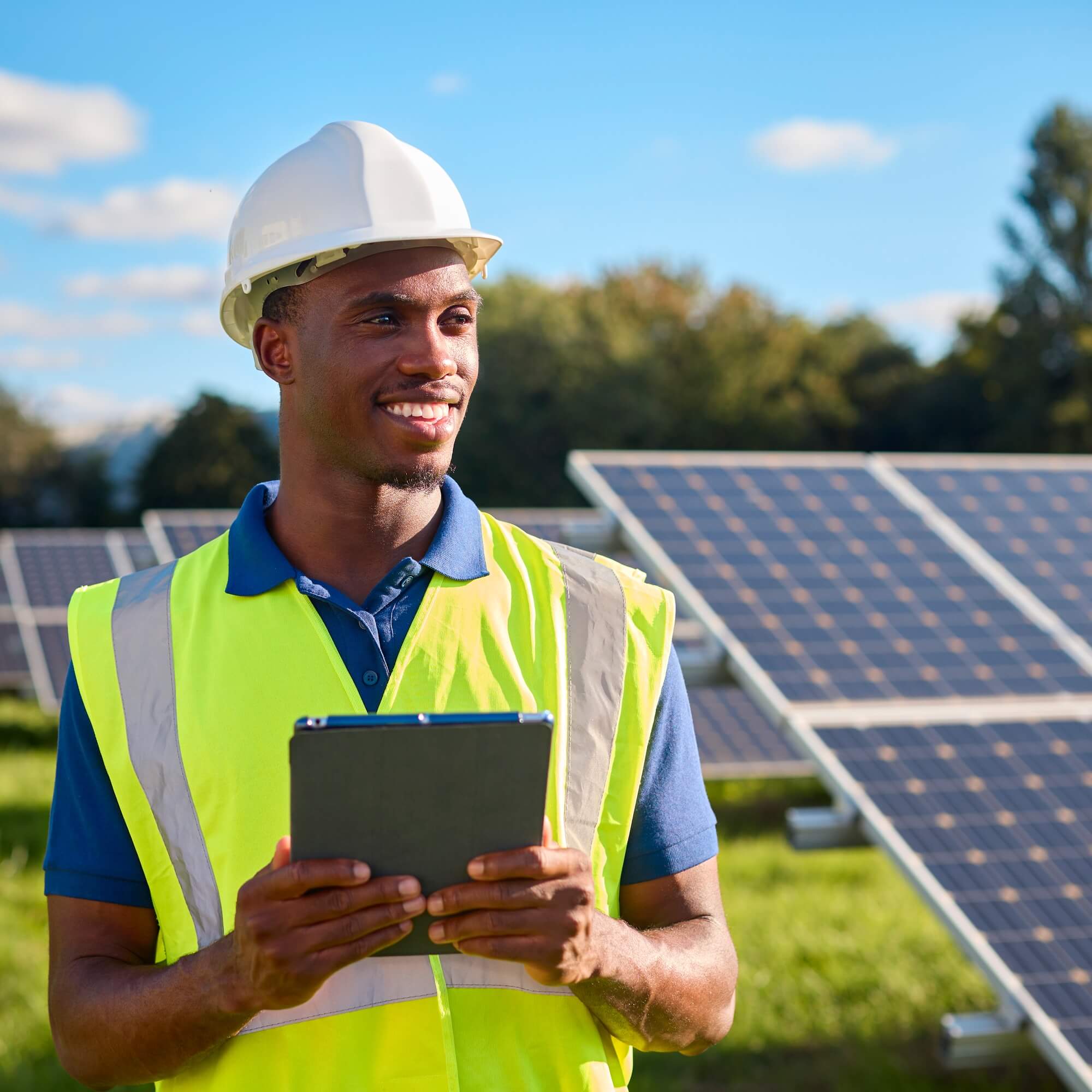 Portrait Of Male Engineer With Digital Tablet Inspecting Solar Panels Generating Renewable Energy