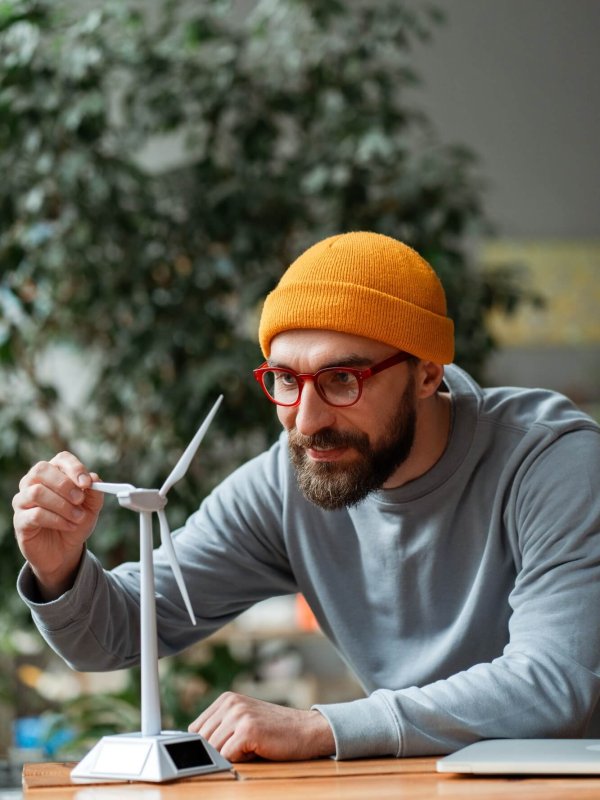 Engineer examining small wind turbine model for renewable energy project
