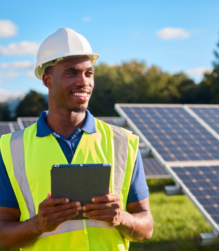 Portrait Of Male Engineer With Digital Tablet Inspecting Solar Panels Generating Renewable Energy