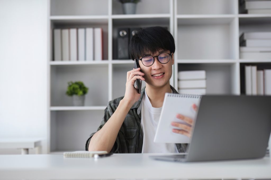 Young Asian man uses laptop to work on financial management. Financial transactions and use of