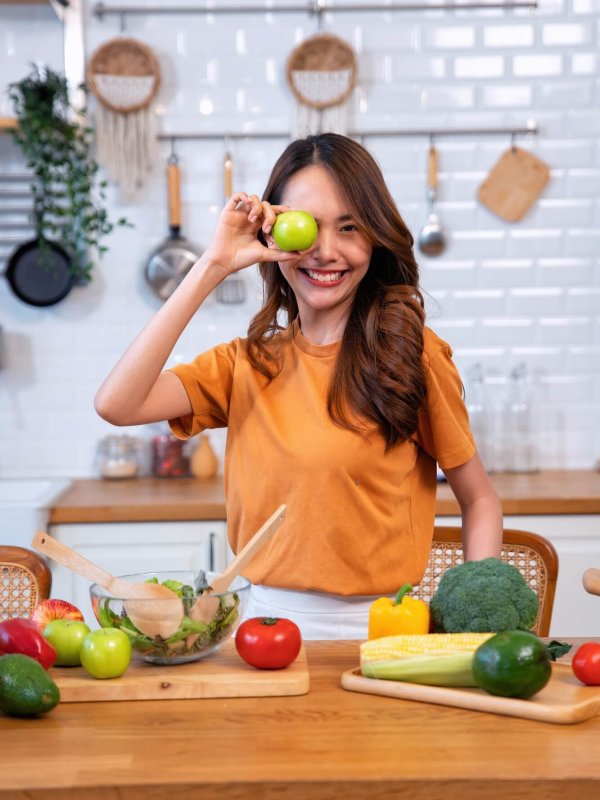 Beautiful young woman happy portrait cooking fresh organic clean food fruit at home modern kitchen