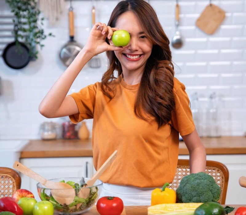 Beautiful young woman happy portrait cooking fresh organic clean food fruit at home modern kitchen