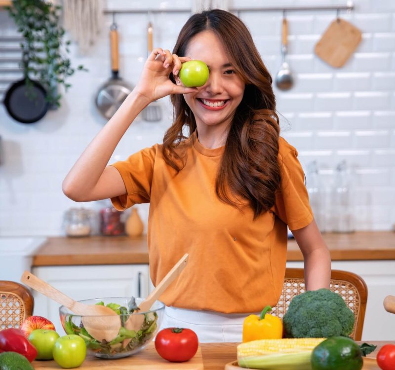 Beautiful young woman happy portrait cooking fresh organic clean food fruit at home modern kitchen