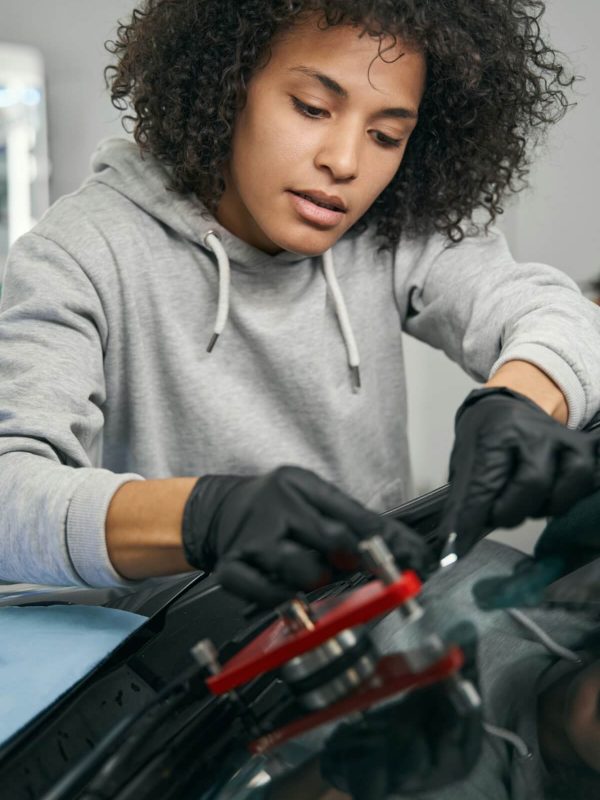 concentrated-auto-mechanic-installing-windshield-crack-repair-bridge