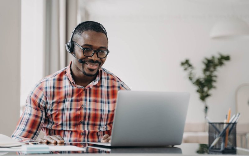 African american male student wearing headset learn language online at laptop. Distance education