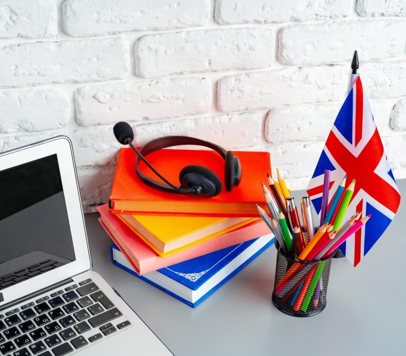 Laptop and flag of UK on desk. English language learning concept