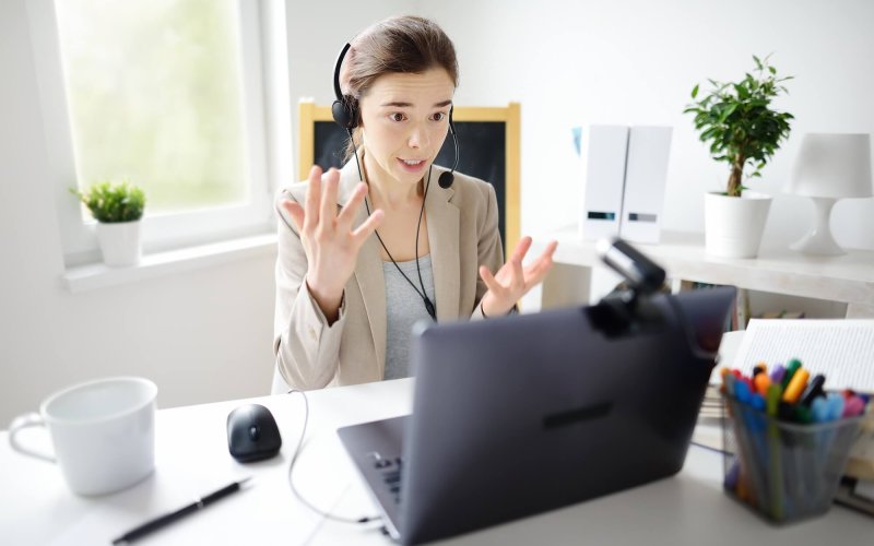 Young woman is learning language with laptop computer, camcorder and headphone online at home.