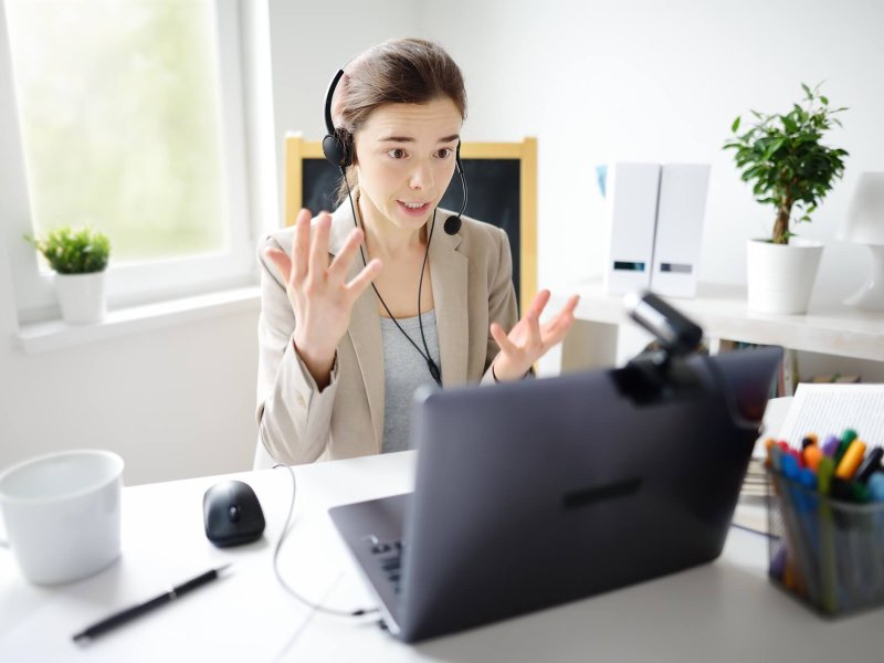 Young woman is learning language with laptop computer, camcorder and headphone online at home.