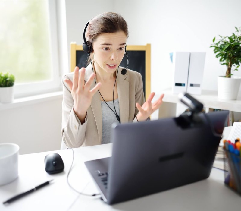 Young woman is learning language with laptop computer, camcorder and headphone online at home.