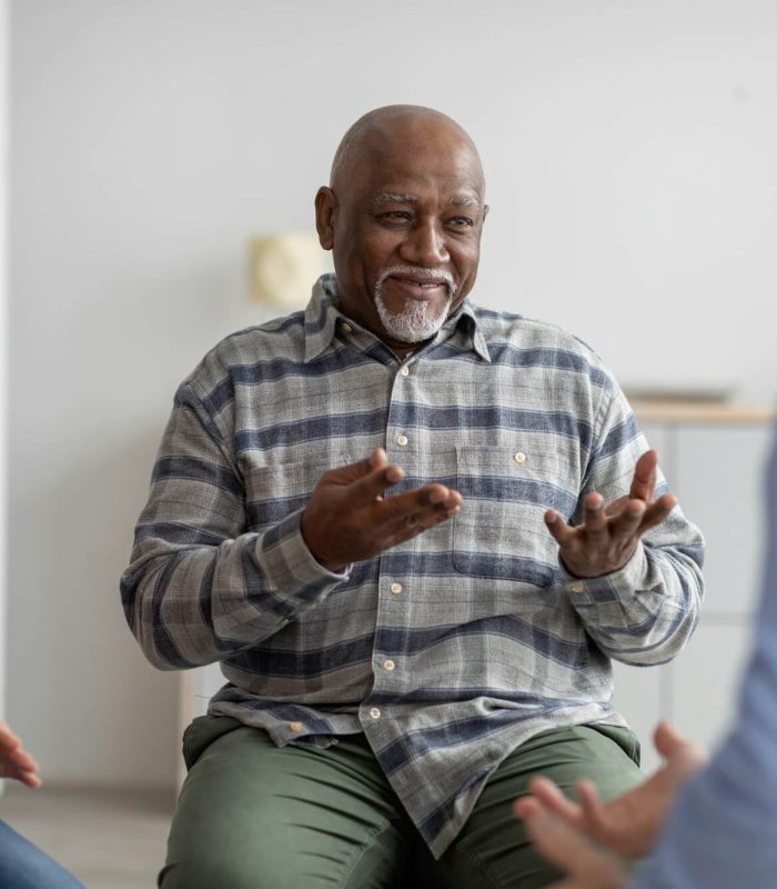 Cheerful african american elderly man having conversation with coach