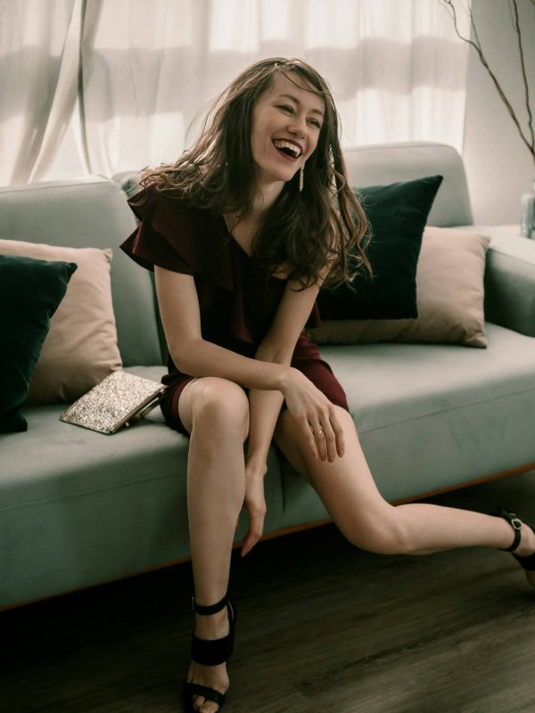 Fancy young lady in a cocktail dress and high heels on the green coach