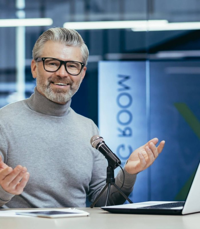 Successful mature financier business coach teacher working inside office with laptop and