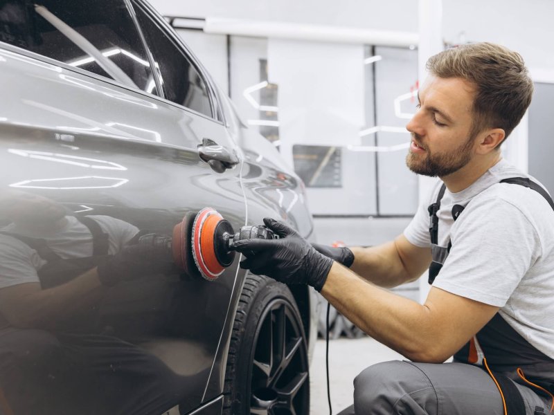 Professional Car Detailing with an Auto Polisher in a Garage Setting