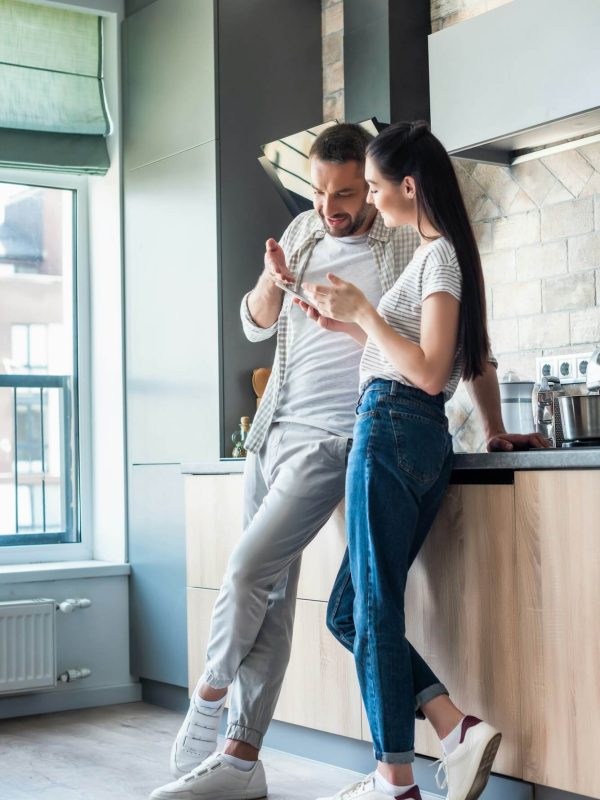couple-using-smartphone-together-in-kitchen-smart-home-concept