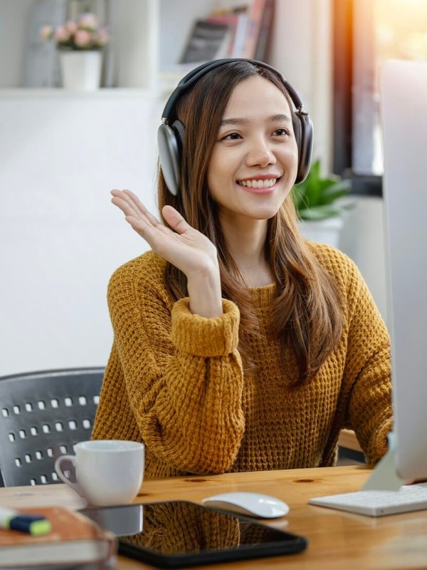 Young beautiful asian woman with headphone sitting at home office, Video call event with clients.
